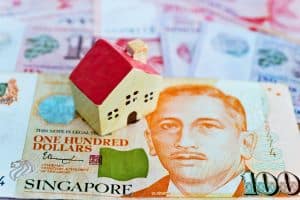 Des billets singapouriens avec une petite maison, pour symboliser la notion de salaire à Singapour.