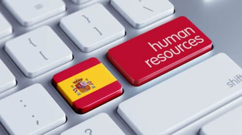 un clavier avec une touche représentant un drapeau espagnol et une autre avec les mots "human resources" pour représenter le droit du travail en espagne