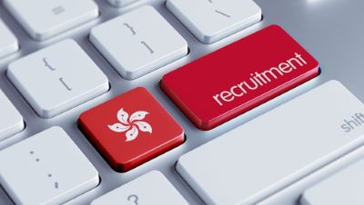 un clavier d'ordinateur, avec une touche aux couleurs du drapeau hongkongais et les mots "recruitment", pour représenter les obligations de l'employeur lors de l'élaboration du contrat de travail à Hong Kong.