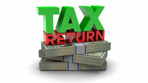 Des billets américains avec les mots "tax return", pour représenter l'Impôt sur les sociétés aux USA